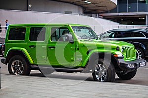 Green Jeep Wrangler Unlimited 4x4 SUV car parked on the street in the city