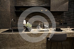 MOSCOW / RUSSIA - 04/03/2019 luxurious spacious modern kitchen island in black grey brown stone marble tones, a sink, a