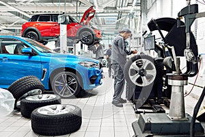 Moscow, Russia, 09.05.2019, a man repairs cars in a car repair shop, many wheels, BMW, tire fitting