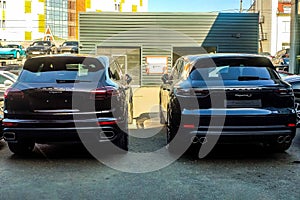 Moscow, Russia - May 18, 2019: New and old generation of Porsche Cayenne in gray-blue color parked on the street. Back side,