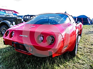 Moscow, Russia - May 25, 2019: Red Chevrolet Corvette Stingray parked on the grass. The classic vintage American sports car