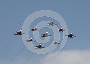 The `Strizhi` and `Russian Knights` aerobatic teams are flying in the sky over Red Square during the parade. photo