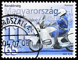 Postage stamp printed in Hungary shows Policeman on motorbike and emergency phone number, Police serie, circa 2003