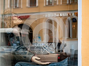 Dolls depicting fairytale heroes in a window of a Moscow Puppet Theater. The figure of a man sitting with box in hand.