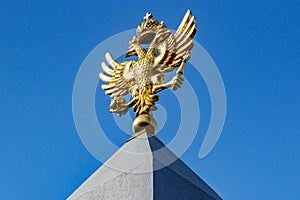 Moscow, Russia - September 13, 2019: Gilded russian double-headed eagle against deep blue sky in sunny day. Bottom view