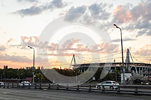 Moscow, RZD-arena stadium, summer evening, sunset. View from the side of the road. Cars are moving along the road.