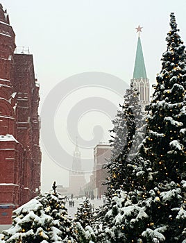 Moscow`s snow-covered Kremlin and the Historical Museum among tall fluffy firs