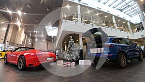 Moscow. Winter 2019. New year in Porsche Center. 911 Carrera and Macan near christmas tree. Presents in the trunk