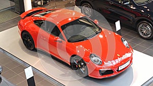 Moscow. Winter 2019. Bright Orange Porsche Carrera 911 991 4s in showroom. Top view