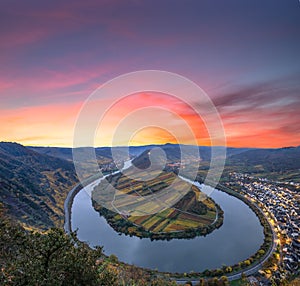 The Moselle and its Moselle loop at Bremm in Germany. View over a valley, sunrise, autumn and vineyards with autumn leaves