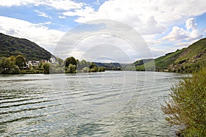 The Moselle river in western Germany near the mouth of the river in Koblenz in the background buildings and wineries, the water fl