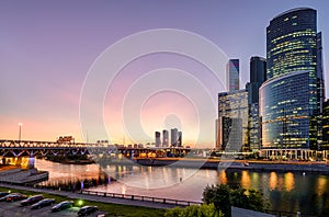 Moskva River with skyscrapers and bridge at dusk, Moscow, Russia