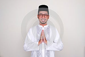 Moslem Asian man smiling at the camera with hand praying pose