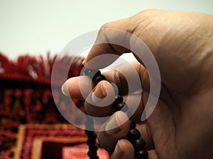 Moslem man praying using wooden beads