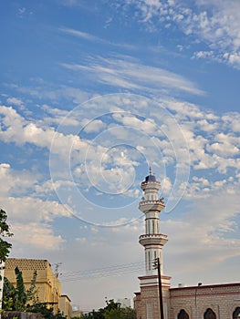Mosque minare with scattered clouds sky, Oman