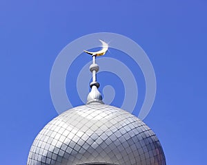 Mosque of Muslim. Crescent on copper covered dome and minaret of mosque against blue sky. Symbol of Islam and Ramadan.
