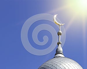Mosque of Muslim. Crescent on copper covered dome and minaret of mosque against blue sky. Symbol of Islam and Ramadan