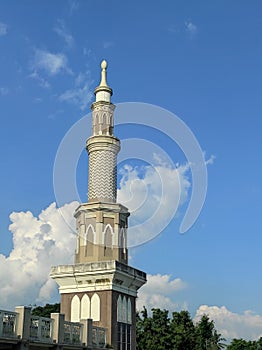 The mosque tower is backdropped by a clear sky photo