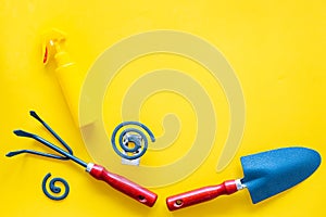 Mosquito protection for garden. Mosquito coil and spray near garden tools on yellow background top view copy space