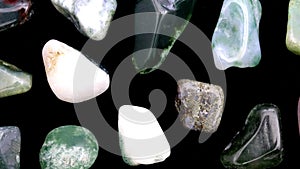 Moss agate rare jewel stones texture on black background. Moving right seamless loop backdrop