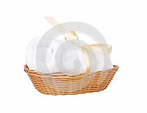 Mossy white rolled towel in wicker basket isolated on white background