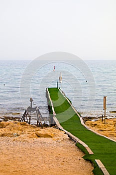 Plank footpath extending over calm water photo