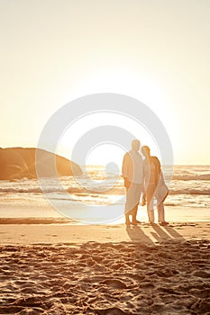 The most beautiful sunset. Full length shot of an affectionate middle aged couple standing on the beach at sunset.