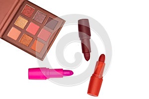 most classic lipsticks colours dark red, bright pink and vivid red and eye shadows on a white background