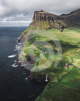 Most famous landmark of the Faroe Islands, a waterfall flowing down over the cliffs in the ocean