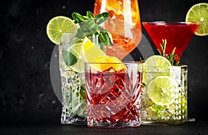 Most popular cocktail drinks set: aperol spritz, negroni, mojito, gin tonic and cosmopolitan on black bar counter background