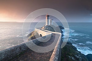 Most popular lighthouse in Europe during stormy weather. Petit Minou Lighthouse at sunset with red light, Brest , France