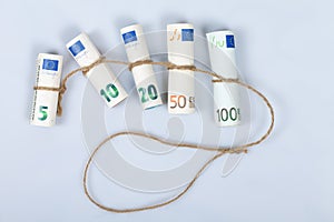 The most used euro bills for Europeans tied with a rope and isolated on white