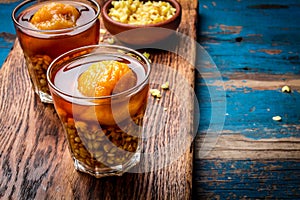 Mote con huesillo. Traditional Chilean drink made from cooked husked wheat and dried peach on wooden board, rustic blue