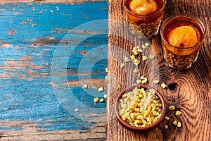 Mote con huesillo. Traditional Chilean drink made from cooked husked wheat and dried peach on wooden board, rustic blue photo