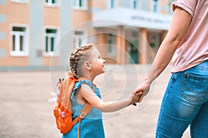 Mother accompanies to school and supports her daughter morally, holding hands photo