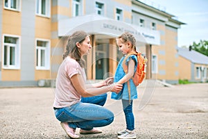 Mother accompanies to school and supports her daughter morally, holding hands photo