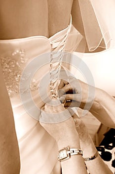 Mother adjusting wedding dress to a bride