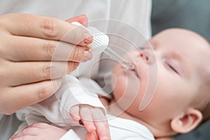 Mother administers oral drops to newborn, Concept of ensuring baby's health