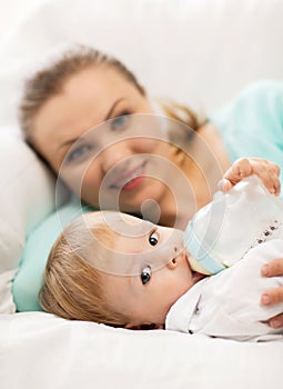 Mother and adorable baby with feeding-bottle