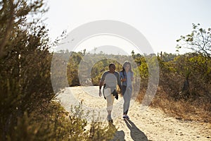 Mother And Adult Daughter Hiking Outdoors In Countryside