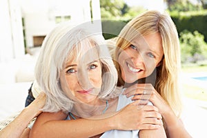 Mother And Adult Daughter Relaxing On Sofa