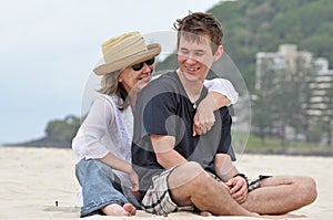 Mother & adult son sharing a laugh on beach