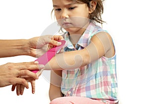 Mother applying kinisiology tape to her daughter injury hand