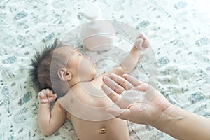 Mother are applying a lotion cream on the baby body after bath