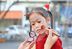 Mother applying makeup on her daughter face