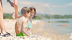 Mother applying sunblock cream on her son shoulder. Sun protection of childs skin.