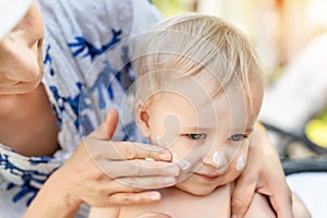 Madre el uso crema proteccion sobre el lindo pequeno un nino chico. madre loción sobre el proteger un nino 