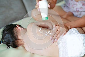 Mother applying Talcum powder for her baby after bath