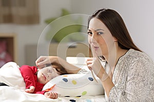 Mother asking for silence with her toddler sleeping photo