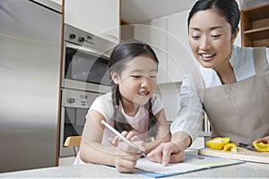 Mother Assisting Girl With Homework